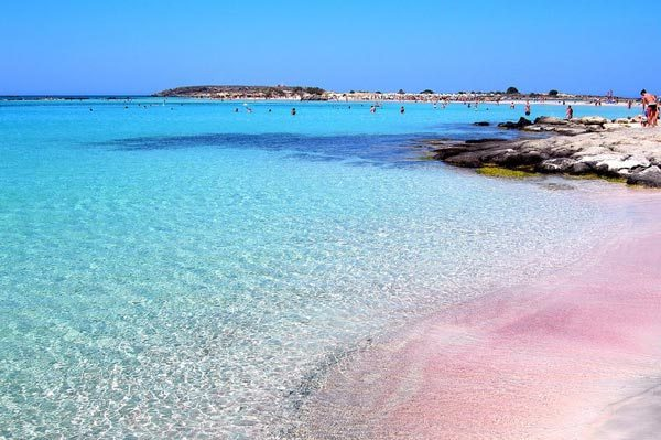 Pink Beach Balos, Crete, Greece. It has patches of white and pink sand. With Sunset, the accents of pink show more from the sky. https://moco-choco.com/2013/04/04/7-amazing-pink-beaches-in-the-world/